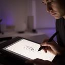 Artista caligráfico digital trabajando con una tableta gráfica en un estudio tranquilo