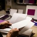 Responsable de marca premium en un taller de papelería con muestras impresas de tinta y relieve